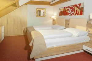 a bedroom with two beds and a painting on the wall at Hotel Kufsteinerhof in Kufstein +27 photos