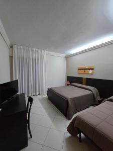 ein Schlafzimmer mit zwei Betten und einem Flachbildfernseher in der Unterkunft B&B Armony 111 in Gioia Tauro