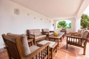 a living room with chairs and tables and a window at ClickSardegna Villa Emanuel spectacular sea view, with independent swimming pool in Alghero
