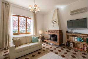 a living room with a couch and a television at ClickSardegna Villa Emanuel spectacular sea view, with independent swimming pool in Alghero