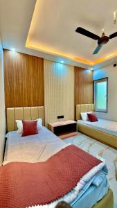 a bedroom with two beds and a ceiling fan at HOTEL RR Grand in Varanasi +35 photos