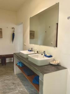 a bathroom with two sinks and a large mirror at Komba on the Rocks in Nosy Komba +71 photos