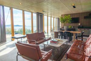 a living room with chairs and tables and a kitchen at KAMOME SLOW HOTEL in Awaji