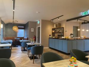 a restaurant with tables and chairs and a counter at DuinHotel Texel in De Koog