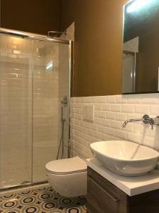 a bathroom with a sink and a toilet and a shower at Camera Albergo - Suites Mansion in Rozzano