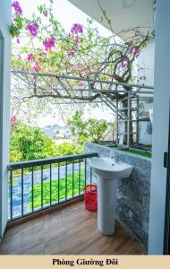 a bathroom with a sink and a balcony with flowers at Green Homestay in Danang