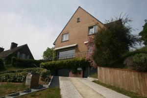 una casa de ladrillo con valla y entrada en B&B Soluna, en Oostduinkerke