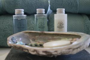 three bottles of soap and a bowl on a table at B&B Soluna in Oostduinkerke
