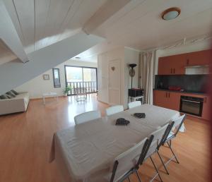 a dining room with a white table and chairs at Le Temps d'une Pause in Andert-et-Condon