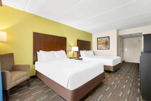 a hotel room with two beds and a chair at Comfort Inn Chula Vista San Diego South in Chula Vista +30 photos