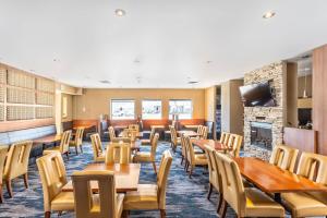 a dining room with tables and chairs and a fireplace at Quality Inn & Suites in Winnipeg
