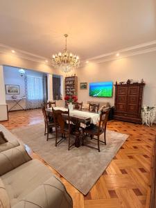 a dining room with a table and a tv at Sunny Flower in Kutaisi