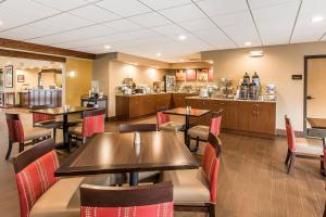 a restaurant with tables and chairs and a kitchen at Comfort Suites Effingham Central in Effingham