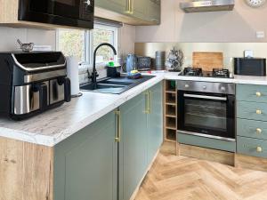 a kitchen with blue cabinets and a sink and a stove at Seren - Uk51711 in Cockermouth