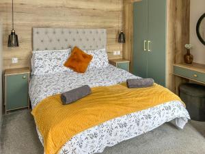 a bedroom with a large bed with a yellow and white blanket at Seren - Uk51711 in Cockermouth +5 photos