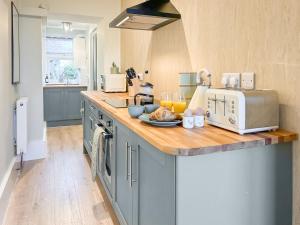 a kitchen with blue cabinets and a counter with a toaster at Rose Cottage in Freuchie