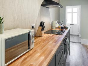 a kitchen with a microwave on a counter top at Rose Cottage in Freuchie +5 photos