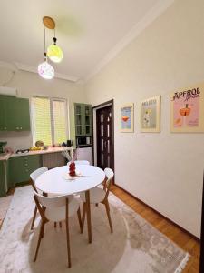 a kitchen with a white table and chairs at Sunny Flower in Kutaisi