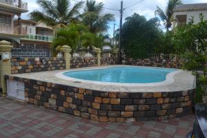 a brick retaining wall around a swimming pool at RS VILLA private apartment with pool and free wifi in Flic-en-Flac