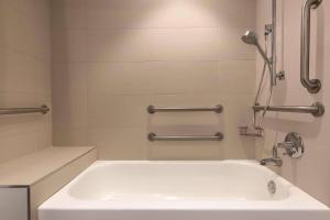 a white bath tub in a bathroom with a shower at Radisson Hotel Seattle Airport in SeaTac