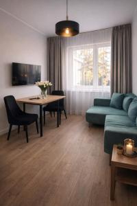 a living room with a couch and a table at New Corner Apartamenty in Niechorze