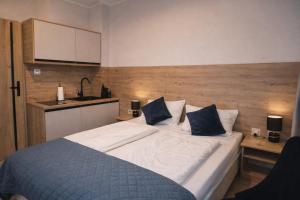 a bedroom with a large bed and a kitchen at New Corner Apartamenty in Niechorze