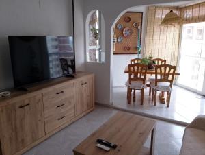 a living room with a television and a dining room table at Cala Morelló in Ifach