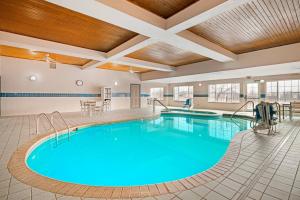 a pool with blue water in a hotel room at Country Inn & Suites by Radisson, West Bend, WI in West Bend
