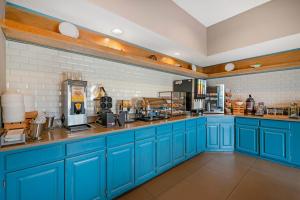 a kitchen with blue cabinets and a counter top at Country Inn & Suites by Radisson, West Bend, WI in West Bend