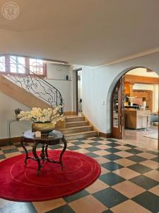 a living room with a table and a staircase at Le Clos des Soyeux in Saint-Victor-sur-Rhins