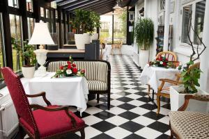 a restaurant with tables and chairs on a checkered floor at Rold Gl. Kro in Rold