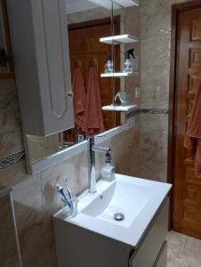 a bathroom with a white sink and a mirror at Cala Morelló in Ifach +11 photos