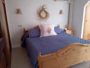 a bedroom with a bed with a blue comforter and a mirror at Cala Morelló in Ifach