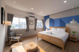 a hotel room with a bed and a chair at Tungyu Home Old Town - 1 min to walking street in Chiang Mai