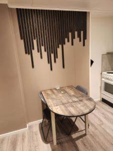 a table in a kitchen with a bunch of sticks hanging on the wall at apartament by the sea in Havøysund