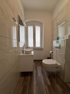 a bathroom with a toilet and a sink and a mirror at Studio Apartman Fictilis in Split