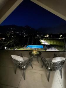 a balcony with two chairs and a table at night at Villa Tarca - Colico, Lake Como in Colico