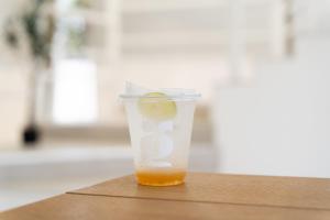 a cup of orange juice sitting on a table at Grood Glamping in Ban Khok Sung