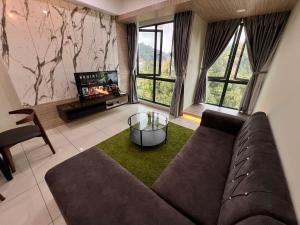 a living room with a couch and a tv at BLUE JADE STUDIOS in Tanah Rata