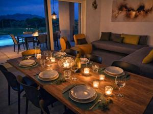 a wooden table with plates and candles on it in a living room at Villa Tarca - Colico, Lake Como in Colico