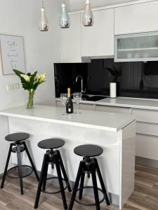 a kitchen with a white counter and three stools at Studio Apartman Fictilis in Split