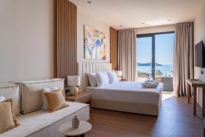 a hotel room with a bed and a couch at Irida Aegean View, Philian Hotels and Resorts in Megali Ammos