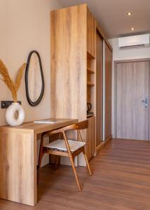 a room with a wooden desk and a mirror at Irida Aegean View, Philian Hotels and Resorts in Megali Ammos