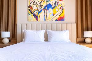 a bedroom with a white bed with two lamps at Irida Aegean View, Philian Hotels and Resorts in Megali Ammos +67 photos