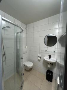 a bathroom with a toilet and a sink and a shower at Hotel Bentley in Brussels
