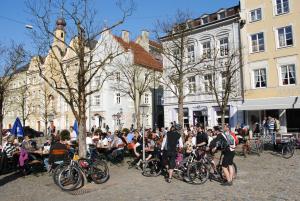 a crowd of people sitting at tables in front of buildings at Hotel Garni Lindacher Hof in Burghausen