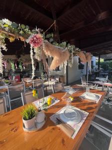 a long wooden table with plates and flowers on it at Mistral Boutique Hotel in Meganisi