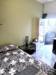 a bedroom with a bed and a table with a lamp at Cocon lumineux tout équipé in Dzaoudzi