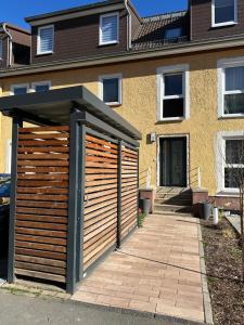 a wooden garage with a roof in front of a house at Ferienwohnung in Kassel mit zwei Schlafzimmer in Kassel