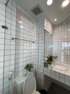 a white tiled bathroom with a toilet and a sink at Fair Dinkum Stay District 1 in Ho Chi Minh City +76 photos